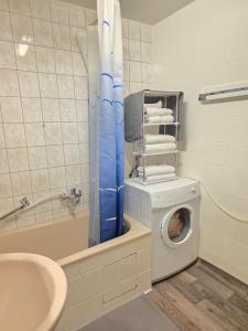 a bathroom with a washing machine next to a bath tub at HappyNest in Böblingen