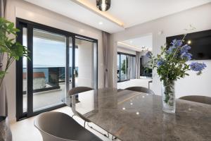 a dining room with a glass table with a vase of flowers at Villa LUX 55 in Tučepi