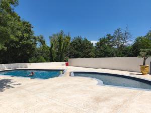 a swimming pool with two people in the water at l'instant provence in Pradons