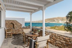 a patio with a table and chairs with a view of the ocean at Studios Kontos in Mikri Vigla