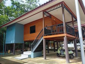 a house with a motorcycle parked in front of it at hadya home in Ko Yao Noi