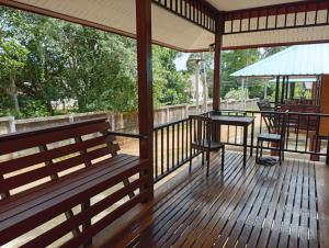 a porch with a bench and a table and an umbrella at hadya home in Ko Yao Noi +14 photos