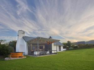 a white house with a grill in a field at Kiekiebos in Wilderness +28 photos