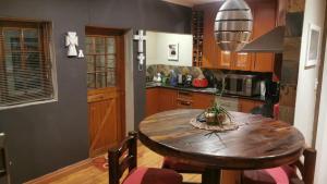 a kitchen with a wooden table with chairs and a table sidx sidx sidx at Walmer Heights Guest House in Port Elizabeth