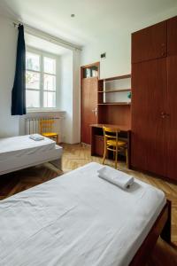 a bedroom with two beds and a desk and a table at The Old Town Hostel-Villa Gradac in Dubrovnik