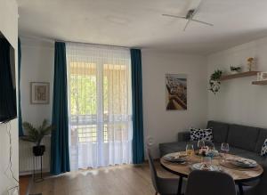 a living room with a table and a couch at Six Apartman in Bükfürdő