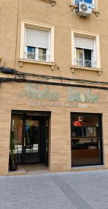 a store sign on the side of a building at Aloha Beach Apartament Con Baño privado in Alicante +2 photos