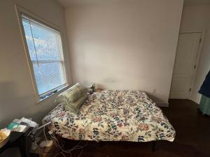 a bedroom with a bed with a floral bedspread and a window at Evanshouse in Stafford