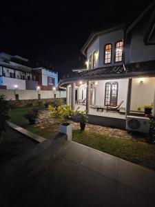 a white house with a bench in front of it at night at Airport Luxury Villa 65 - Negombo-Airport Transit Guest in Negombo