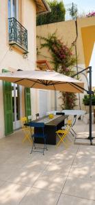 a table and chairs under an umbrella on a patio at Sunset Villa atypical with air conditioning in Nice