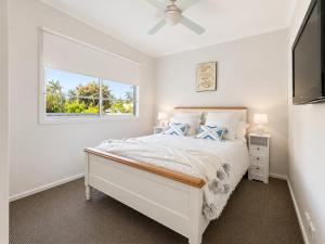 a white bedroom with a bed and a window at Between the Blue Studio in Blacksmiths