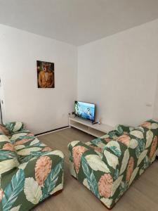 a room with two beds and a flat screen tv at Modern & Comfortable Apartment in Tenerife South in Guargacho