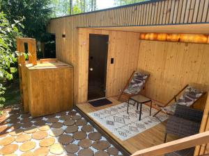 a wooden sauna with two chairs and a table at Agroturystyka Blicharzówka Noclegi in Bukówka