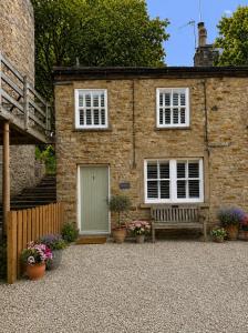 a brick house with a bench in front of it at River Song, Aysgarth Falls in Leyburn