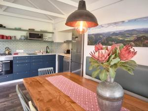 a kitchen with a wooden table with a vase of flowers at Kiekiebos in Wilderness