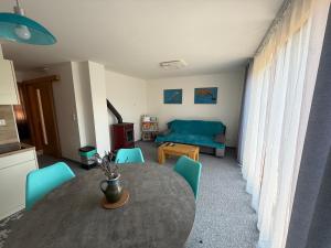 a living room with a table and blue chairs at Čučoriedka Dovolenkový Dom in Hladovka