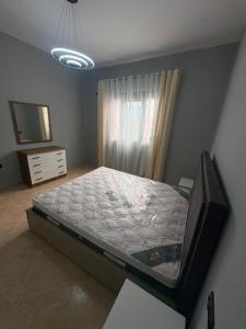 a bedroom with a large bed and a television at Casa bushi in Kamëz