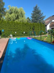 a large blue swimming pool with a playground at Dom lub apartamenty z widokiem na góry Wichrowe Wzgórza z basenem Brenna in Ustroń