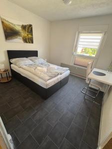 a bedroom with a bed and a desk and a window at Kleine Südharz Auszeit in Heringen
