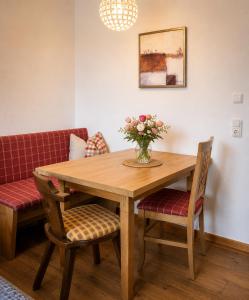 a dining room table with a vase of flowers on it at Dachstein Blick in Bad Goisern +18 photos