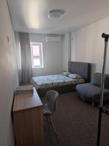 a room with two beds and a desk and a chair at Zarvanska str apartment in Kamianets-Podilskyi
