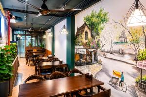 a restaurant with tables and a mural on the wall at Awesome Hanoi Hostel & Travel in Hanoi