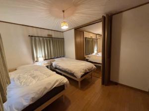 a hotel room with two beds and a mirror at ENZAN STAYS Yamanashi in Enzan