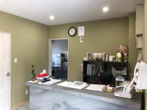 an office with a counter with a clock on the wall at Villa resort -悠- in Miyakojima +50 photos