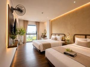 a hotel room with two beds and a window at LAVISH OCEAN INN Đà Nẵng in Danang +42 photos