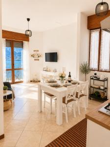 a kitchen and dining room with a white table and chairs at Little house Lezzeno in Lezzeno