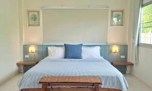 a bedroom with a large bed with a blue comforter at Pranburi Private Pool Villa Baan Prae by Baan Chaylay in Pran Buri
