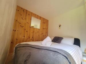 a bedroom with a bed with a wooden wall at Residence Isabella - By Care Concierge in Saint-Gervais-les-Bains
