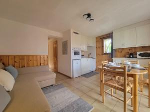 a kitchen and living room with a table and a couch at Residence Isabella - By Care Concierge in Saint-Gervais-les-Bains