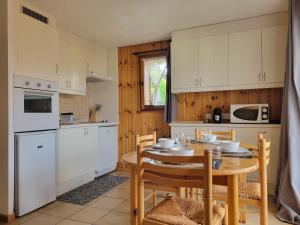 a kitchen with a wooden table and a table and chairs at Residence Isabella - By Care Concierge in Saint-Gervais-les-Bains