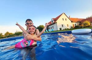 a woman and a girl in a swimming pool at Pension Pod Hvězdami in Božejov