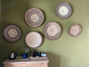 a group of plates hanging on a wall at Tzamenkomst River Lodge in Colesberg +165 photos