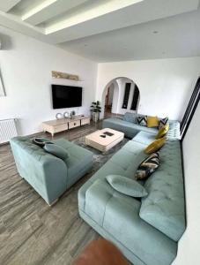 a living room with a blue couch and a tv at Villa Sky in Bin Rhilouf