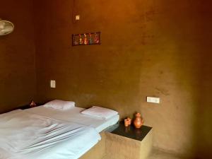 a bedroom with a bed and a small window at Rupani Dhani Farm Stay in Gurgaon