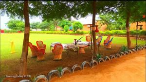 a group of chairs and a table in a park at Rupani Dhani Farm Stay in Gurgaon +20 photos