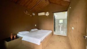 a bedroom with a large bed and a bathroom at Rupani Dhani Farm Stay in Gurgaon