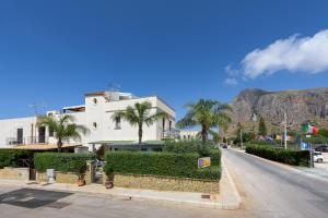 a building on the side of a street with a mountain at Athena Bed & Breakfast in San Vito lo Capo