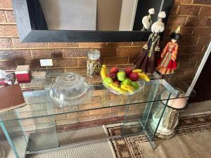 a glass table with a bowl of fruit on it at Highway Haven in Stilfontein