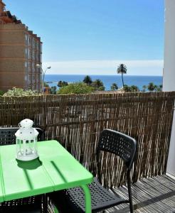 un tavolo verde e sedie su un balcone con vista sull'oceano di Apartamento Flamingo Beach a Benalmádena