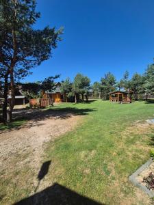 a large yard with a house in the background at Pod lasem dom letniskowy in Majdan Sopocki