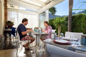a man and woman sitting at a table on a patio at Athena Bed & Breakfast in San Vito lo Capo