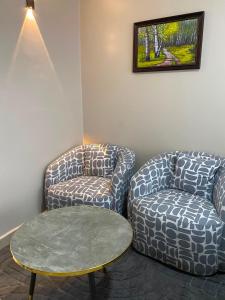 two chairs and a table in a room at The Cozy Corner Studio in Ruaka