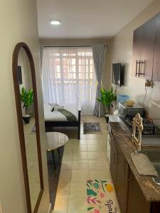 a kitchen and a living room with a couch at The Cozy Corner Studio in Ruaka