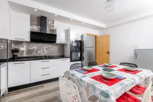 a white kitchen with a table and chairs in a room at Villa Sky in Bin Rhilouf