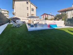 a backyard with a lawn with chairs and tables at VILLA MARIANNA in Marotta