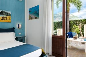 a bedroom with a bed and a large window at Athena Bed & Breakfast in San Vito lo Capo